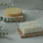 Natural soap bars on marble background with plants and copy space